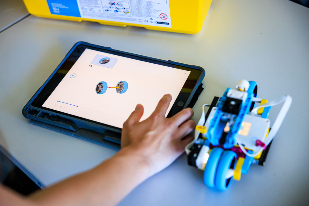 Schüler bedient ein Tablet neben einem LEGO-Roboter beim Technikunterricht an der Weiltalschule.