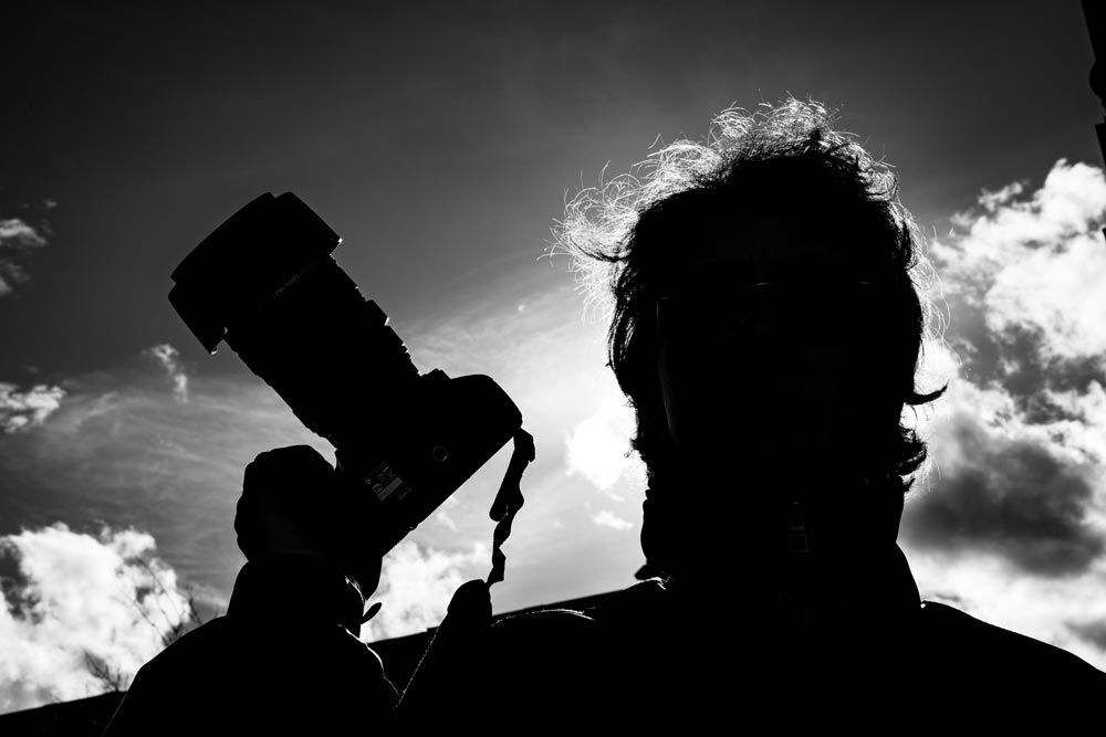 Maria Prozenko fotografiert im Gegenlicht – Silhouette mit Kamera.